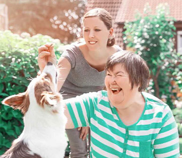 A photo of 2 women petting a dog